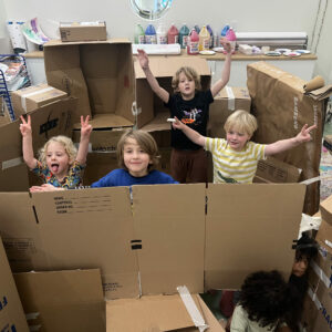 group of small children playing in pile of cardboard boxes